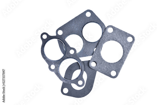 gasket set of automotive paronite exhaust and intake manifold with metal inserts and auto parts on a white background