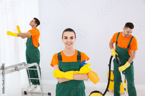 Team of professional janitors cleaning room after renovation