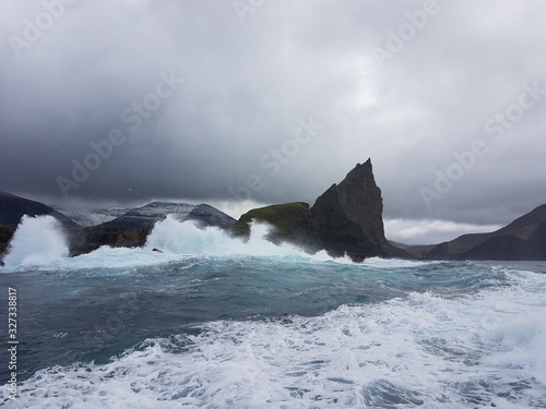 stormy weather at sea with waves over cliffs faroe islands
