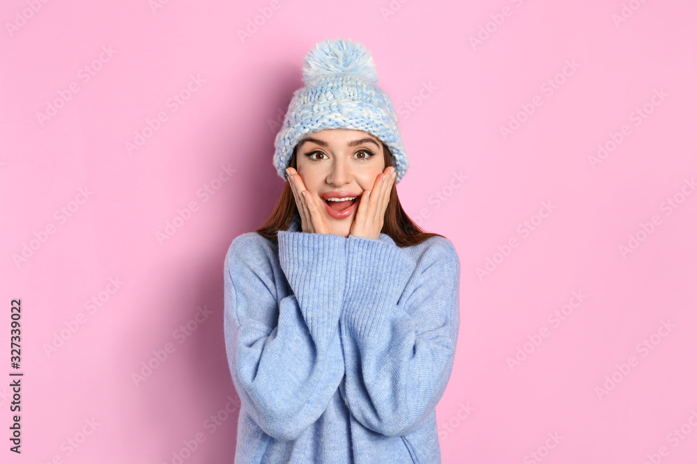 Emotional woman wearing warm sweater and hat on pink background. Winter season Emotional woman wearing warm sweater and hat on pink background. Winter season