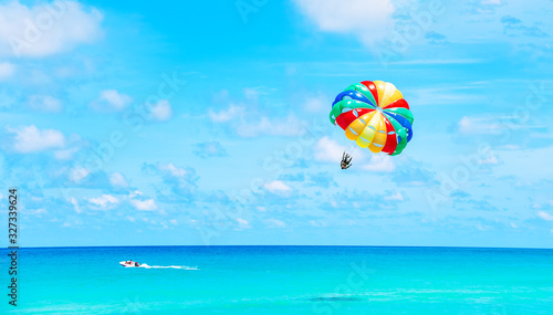 Parasailing above the ocean at tropical islands. Copy space, holiday fun activities. photo