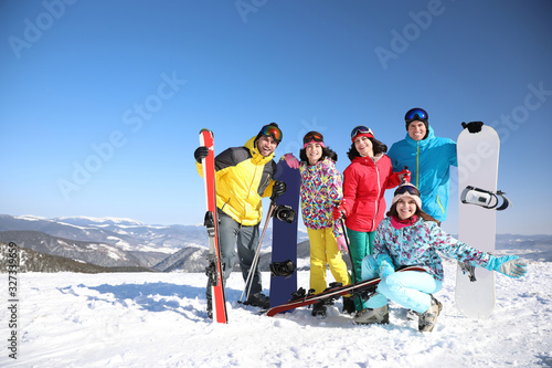 Group of friends with equipment at ski resort. Winter vacation
