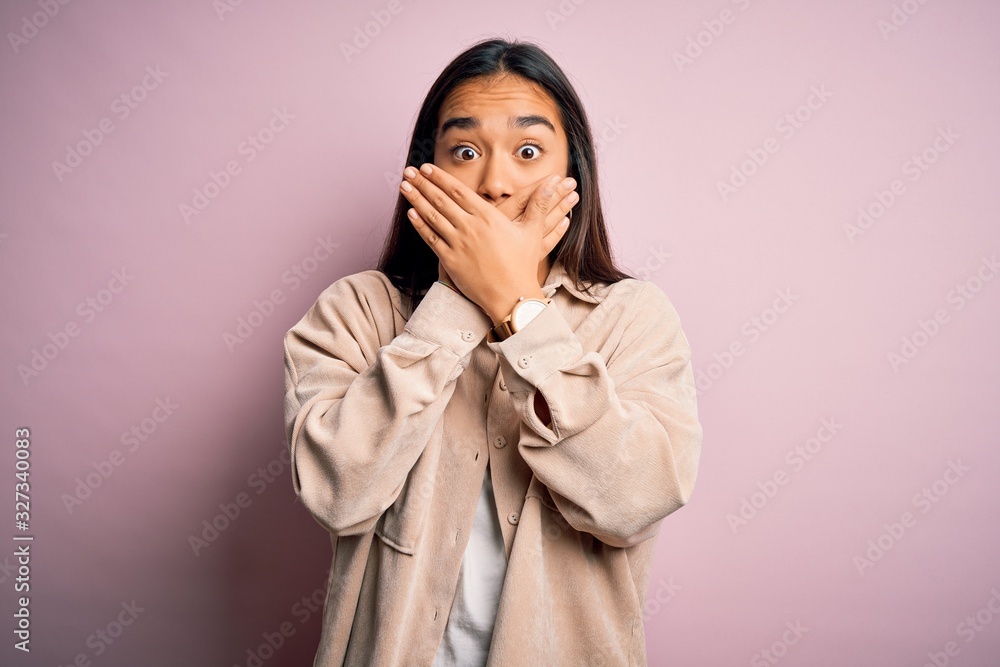 Young beautiful asian woman wearing casual shirt standing over pink background shocked covering mouth with hands for mistake. Secret concept. Young beautiful asian woman wearing casual shirt standing over pink background shocked covering mouth with hands for mistake. Secret concept.
