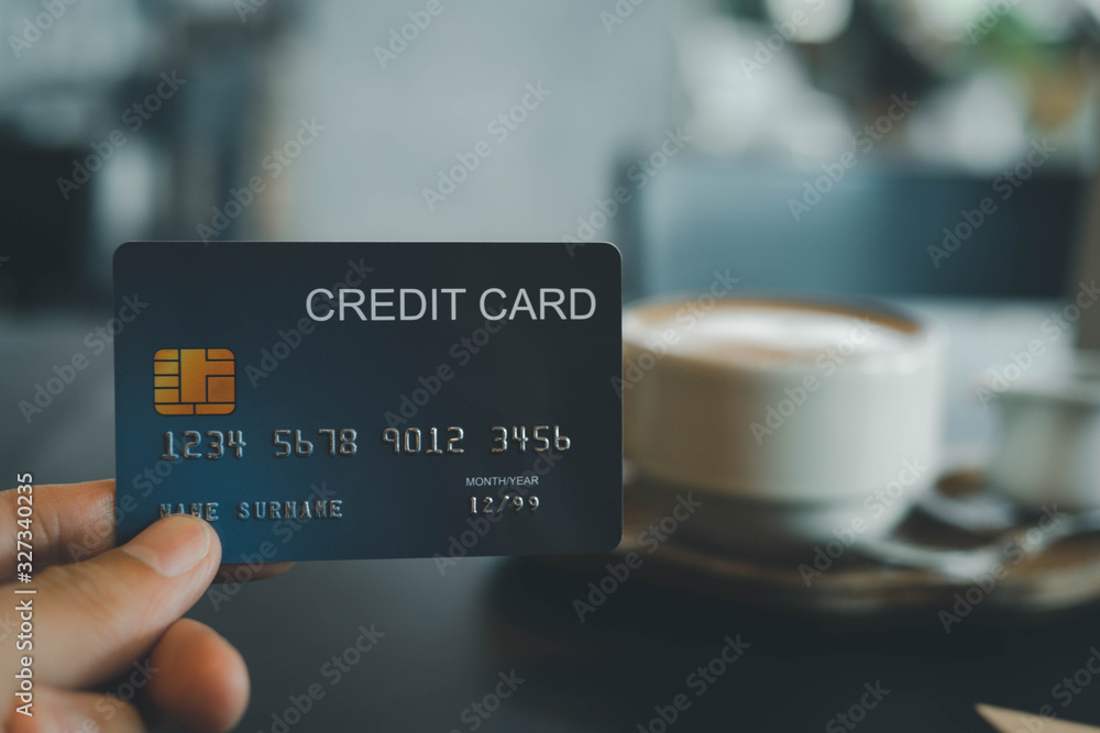 hand holding credit card on coffee shop hand holding credit card on coffee shop