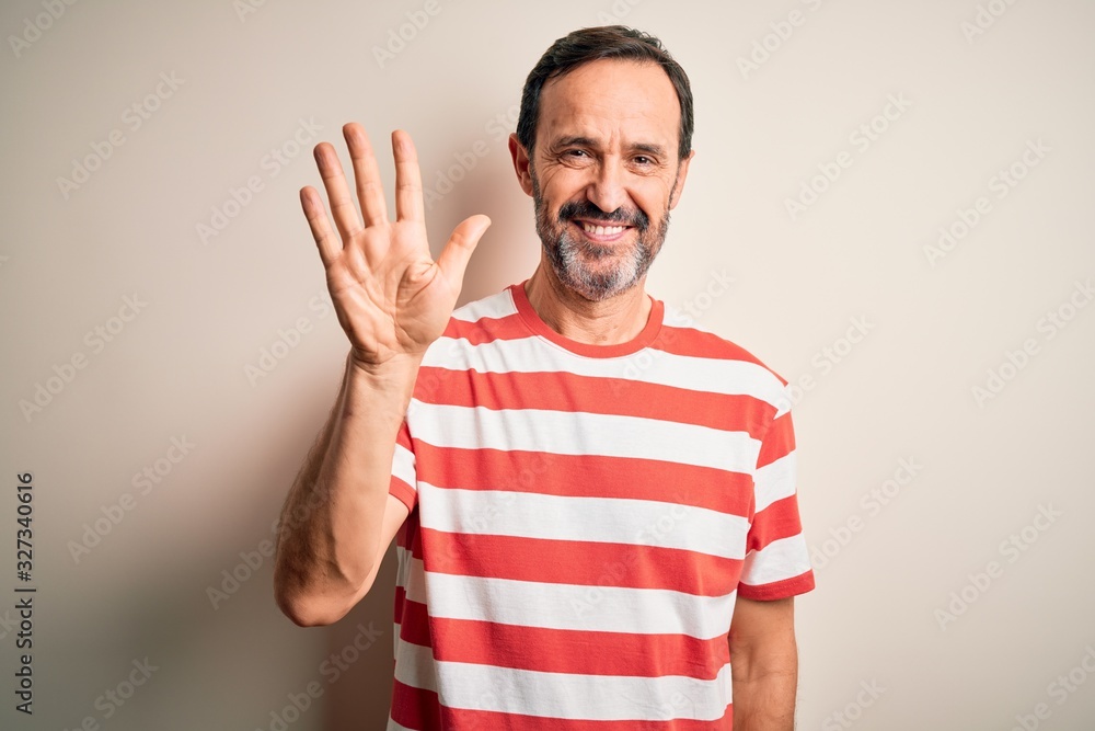 Fototapeta premium Middle age hoary man wearing casual striped t-shirt standing over isolated white background showing and pointing up with fingers number five while smiling confident and happy.
