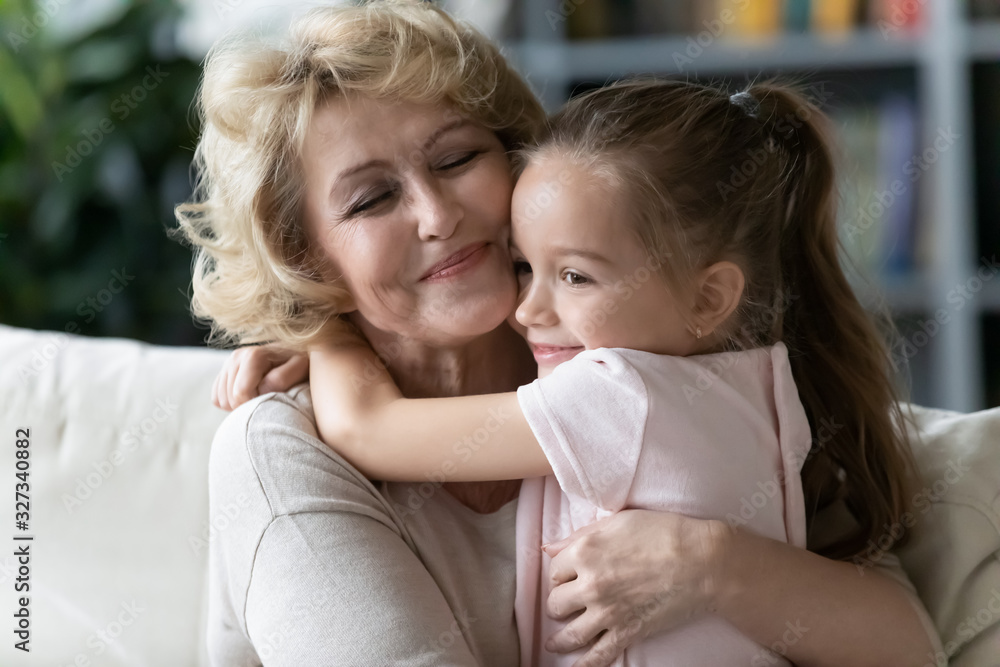 Little girl hug happy 70s grandmother showing love Little girl hug happy 70s grandmother showing love