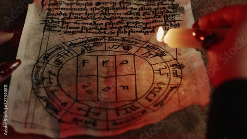 Cropped view of fortune teller dripping wax on pentagram during occult ritual