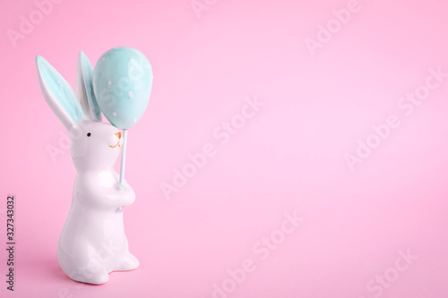 Easter bunny figure on pink background. Space for text
