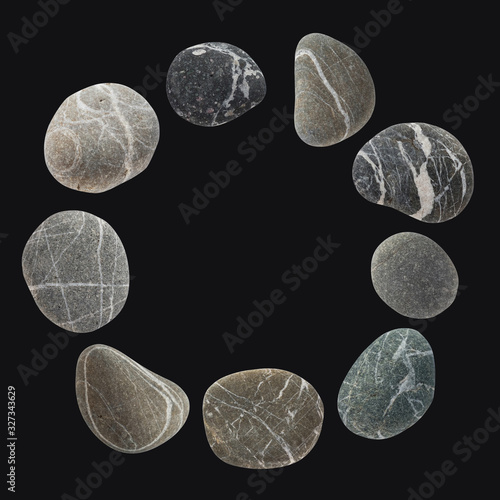 Round frame from a set of different color stones. Stock photo element Scandinavian trend design on dark background.