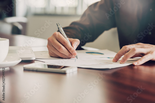 business man hand writing note paper on wooden table photo