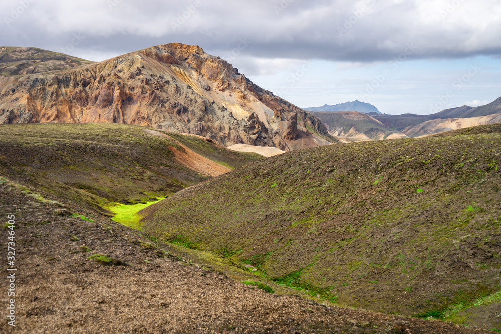 Landmannalaugar Valley. Iceland. Colorful mountains on the Laugavegur hiking trail. The combination of layers of multi-colored rocks, minerals, grass and moss Landmannalaugar Valley. Iceland. Colorful mountains on the Laugavegur hiking trail. The combination of layers of multi-colored rocks, minerals, grass and moss