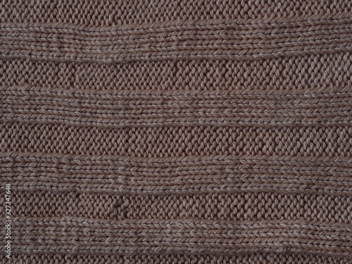 Brown knitted textured background, knit with the front and back loops. Hand knitting.