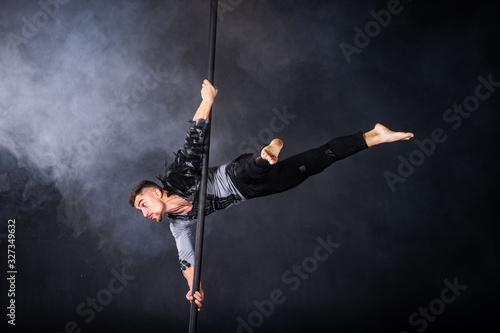 Performance concept. Man hanging on chinese pole. Athlete performing flying pole