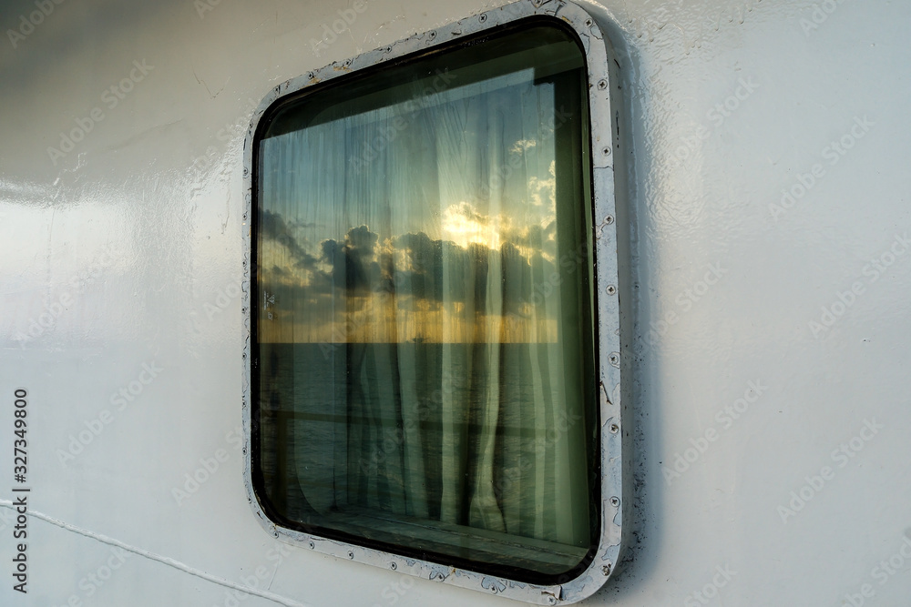 SUnset reflection on the glass window of cabin on a cosntruction work barge at oil field