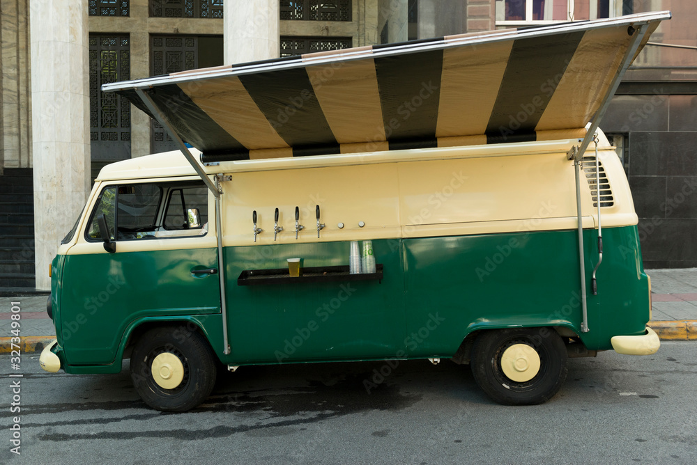 Isolated food truck of beer taps in a vintage green and beige van