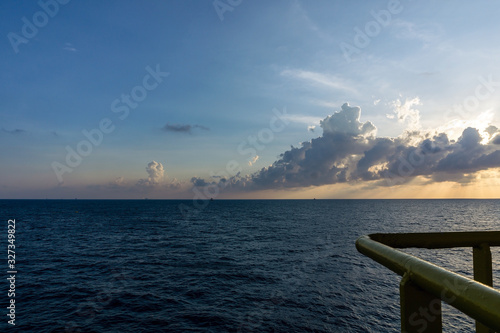 Seascape of oil field during sunset viewed from a constrcution work barge