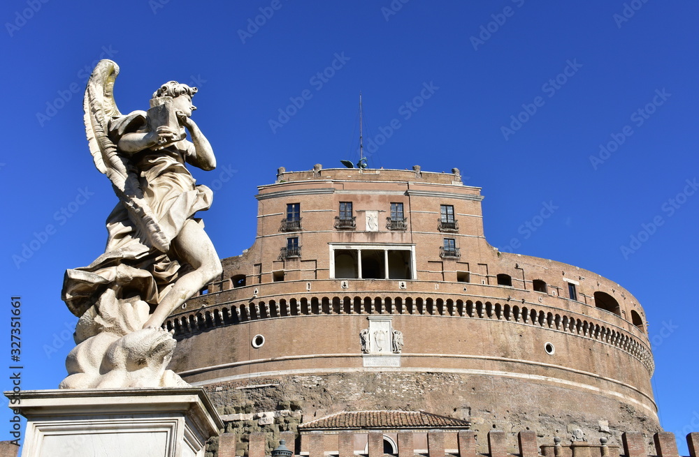 View of Castel Sant’Angelo and marble angel from Ponte Sant'Angelo with blue sky. Rome, Italy.