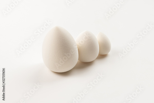Small, medium and large  white beauty blender isolated.
