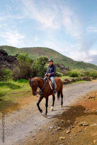 woman walking and discovering the volcanic landscapes of Tenerife on horseback