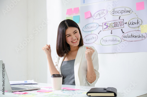 Smiling beautiful asian woman celebrate with laptop happy for success working. Agile for startup small business concept at modern office or co-working space with copy space for label text