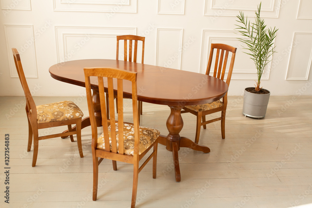 A classic set of wooden furniture for the kitchen. A set of chairs to the table in a classic interior A classic set of wooden furniture for the kitchen. A set of chairs to the table in a classic interior