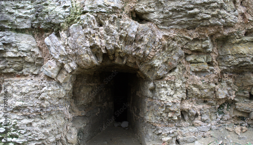 Window in an old medieval castle. Ruins, rough stone. Historical photography. The window is at ground level. Window in an old medieval castle. Ruins, rough stone. Historical photography. The window is at ground level.