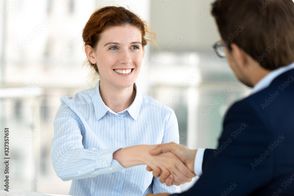 Close up smiling attractive woman handshaking with boss at meeting. Close up smiling attractive woman handshaking with boss at meeting.