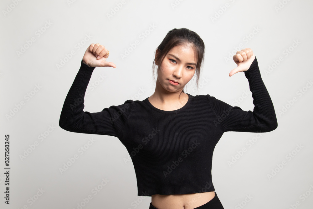 Unhappy Asian girl show thumbs down with both hands. Unhappy Asian girl show thumbs down with both hands.