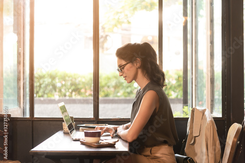 Beautiful woman have coffee in cafe while work in morning freelance, nomad work style