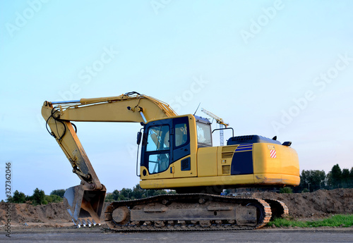 Yellow tracked excavator at a open-pit mining. Crushing and recycling on construction site. Road work. Special heavy construction equipment for road construction.