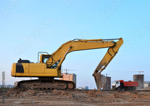 Tracked excavator working at a construction site during laying or replacement of underground storm sewer pipes. Installation of water main  sanitary sewer  storm drain systemsduring - Image