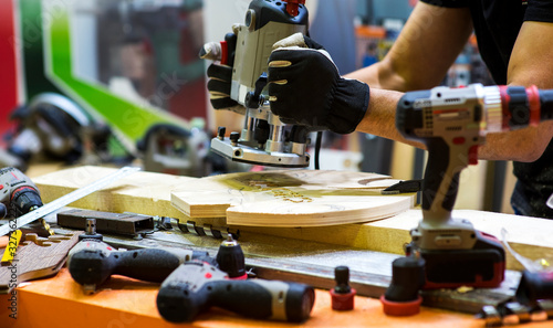 Worker grinds the wood of angular grinding machine