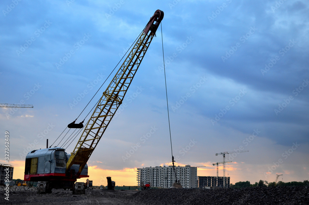 Large crawler crane or dragline excavator with a heavy metal wrecking ball on a steel cable. Wrecking balls at construction sites. Dismantling and demolition of buildings and structures - Image