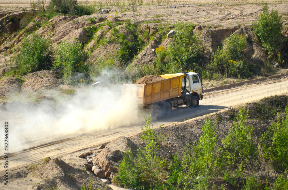 Fototapeta premium Dump truck transports sand and other minerals in the mining quarry.