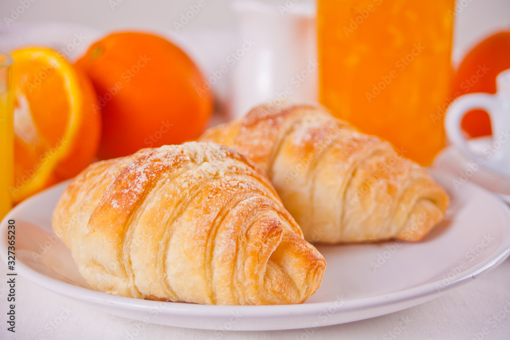 Fresh croissants buns, oranges, orange jam. Breakfast concept.