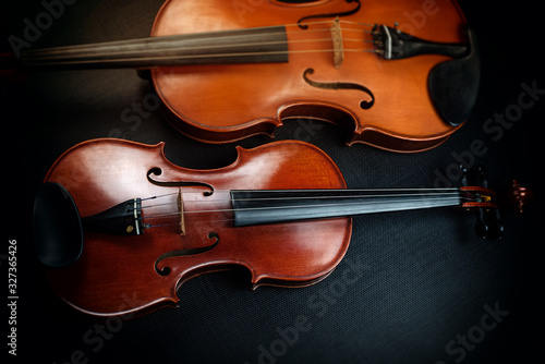 Violin put beside blurred viola,show different size and front side detail of acoustic instrument