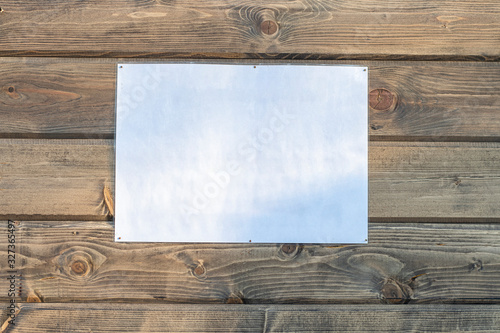 Fotografie An empty, laminated sheet of paper for ads attached to a wooden wall on the stre