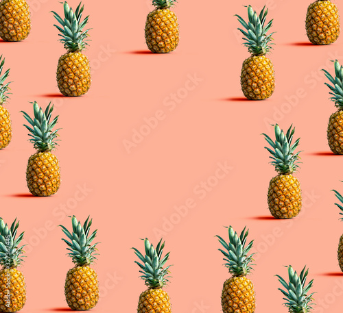 Round frame of pineapples on a solid color background