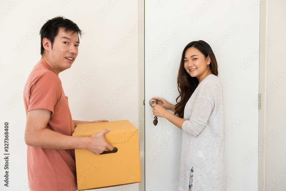 Happy couple open door of new moving house Happy couple open door of new moving house