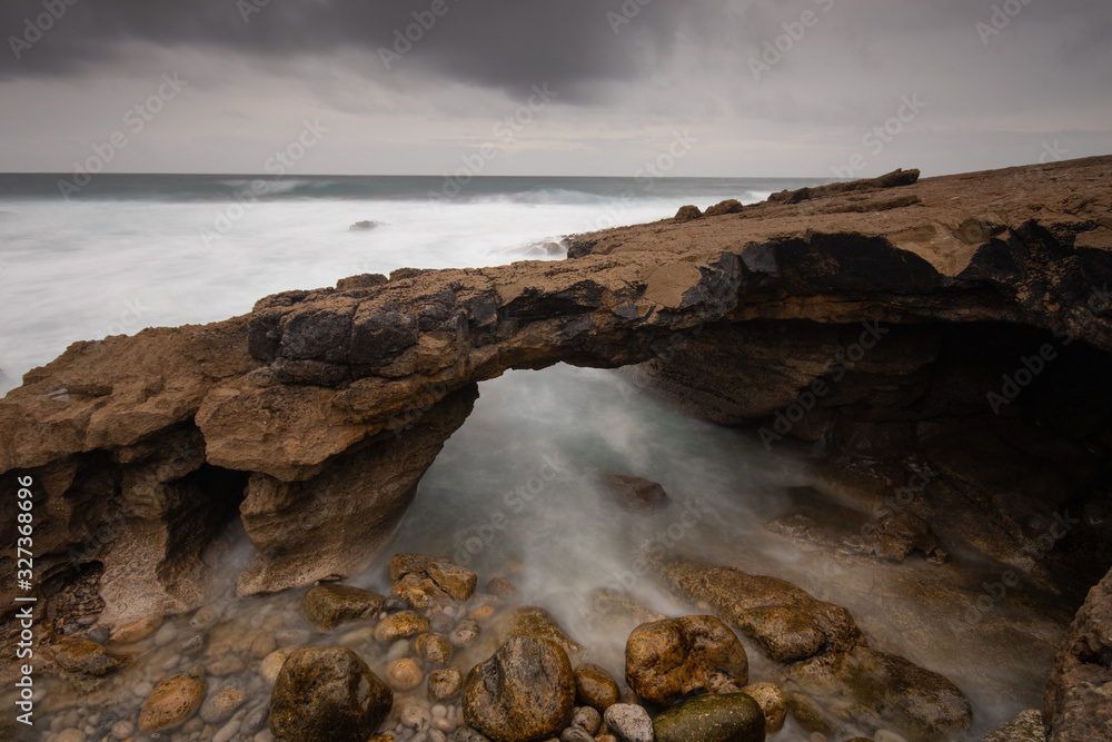 Arch shaped rock formation in the coastline. Long exposure Arch shaped rock formation in the coastline. Long exposure