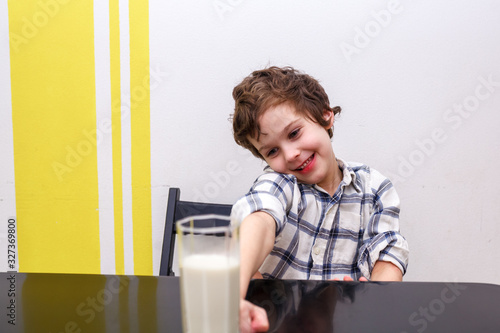 Boy does not want to drink a glass of milk. Source of calcium. Concept of lactose deficiency