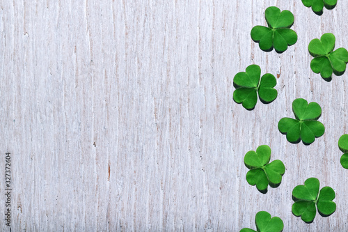 Pattern of shamrock leaves on shabby white wooden background with free copy space. St. Patrick's Day, selective focus.