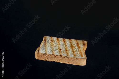 Close up of golden slice of toast on black background photo