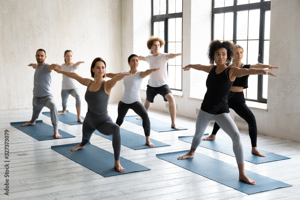 Diverse girls and guys performing Warrior II Virabhadrasana exercise Diverse girls and guys performing Warrior II Virabhadrasana exercise