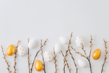 Flat lay easter composition with a willow branch and eggs on a white background