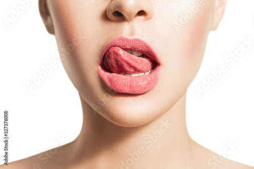 Woman's tongue seductively licking lips. Beautiful chubby lips. seduction concept