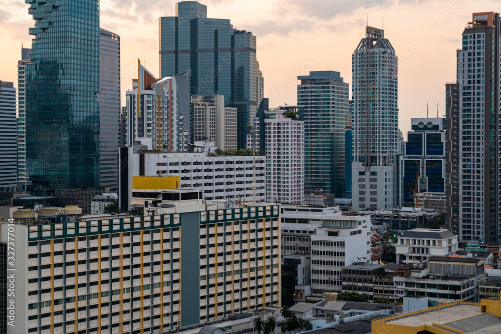 Fototapeta premium Aerial cityscape of picturesque Bangkok at sunset from rooftop. Panoramic sunrise skyline of the biggest city in Thailand. The concept of metropolis.