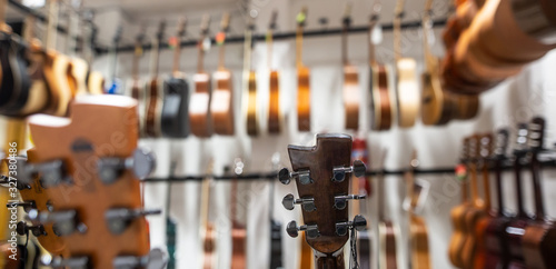 Close up of classic guitar drapped in a row in a huge musical shop, instrument shop, instrument concept