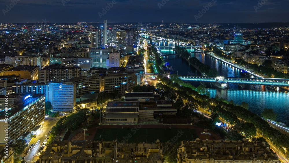 Aerial Night timelapse view of Paris City and Seine river shot on the top of Eiffel Tower