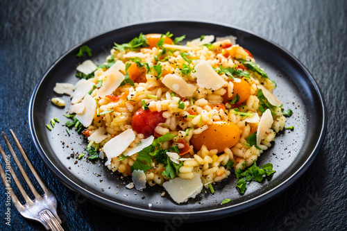 Risotto with parmesan on black stone background